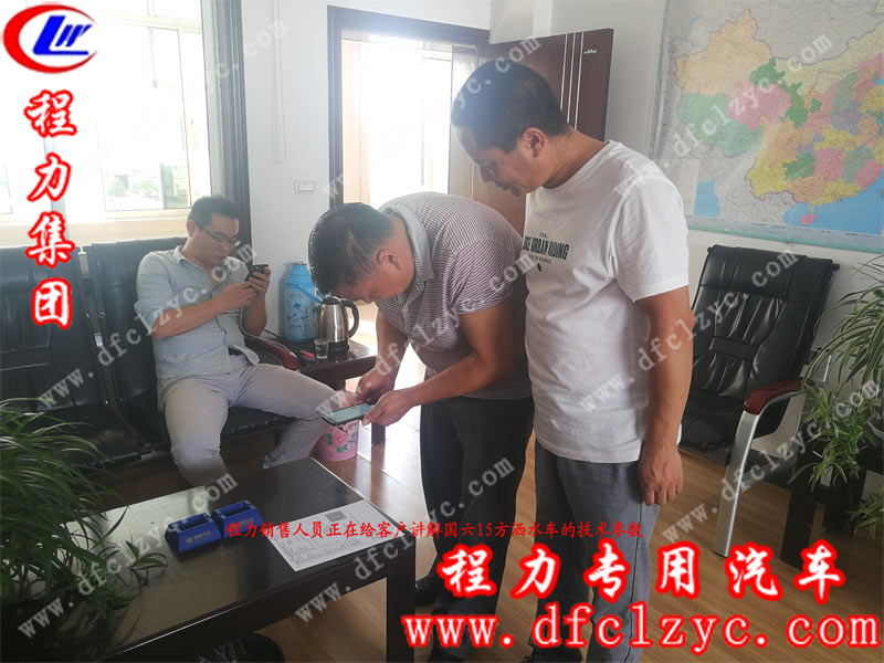 程力銷售人員正在給客戶講解國六15方灑水車的詳細參數